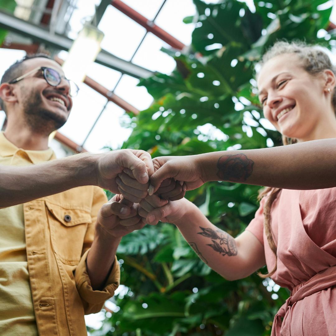 a group of people holding hands in a greenhouse