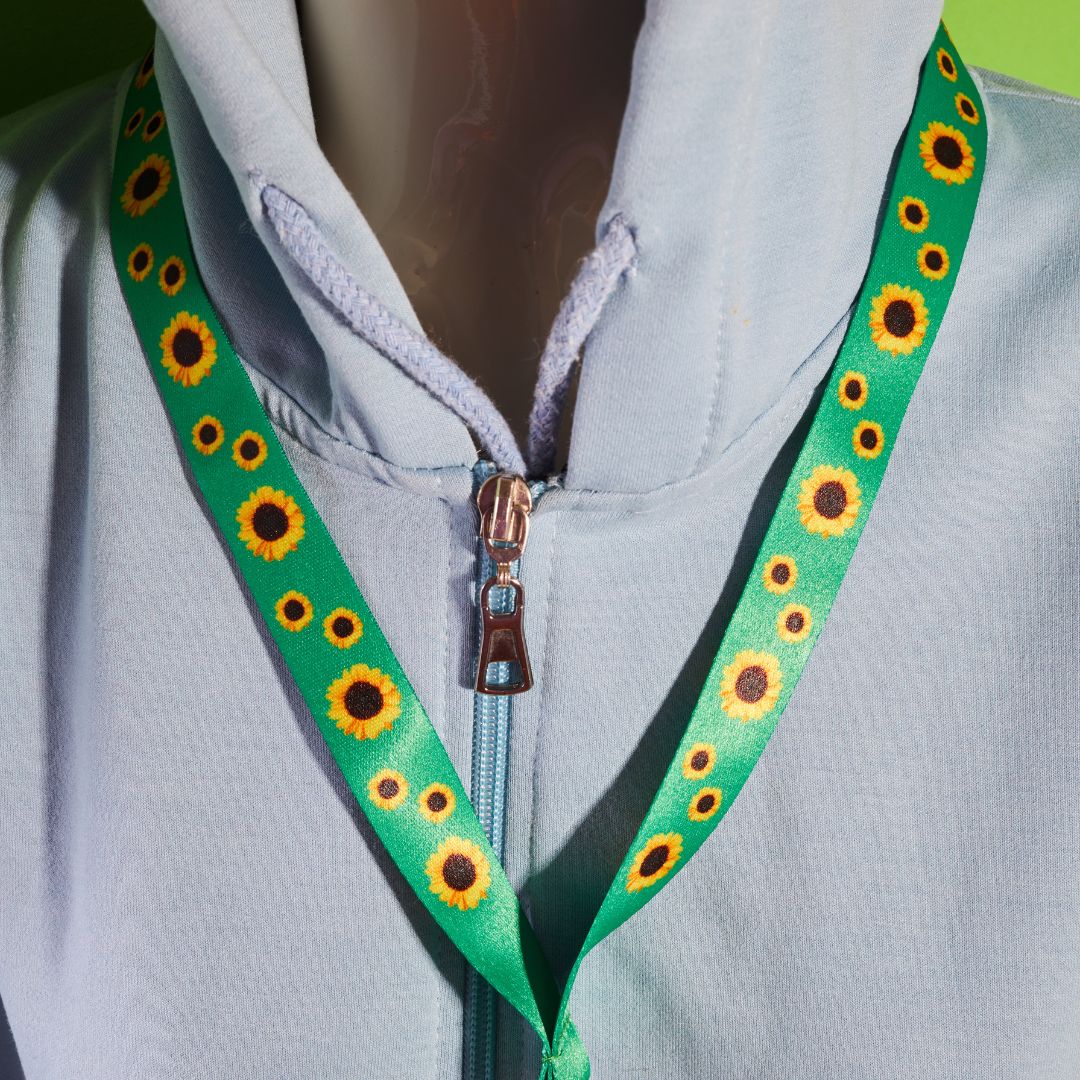 a person wearing a green and yellow lanyard with sunflowers on it