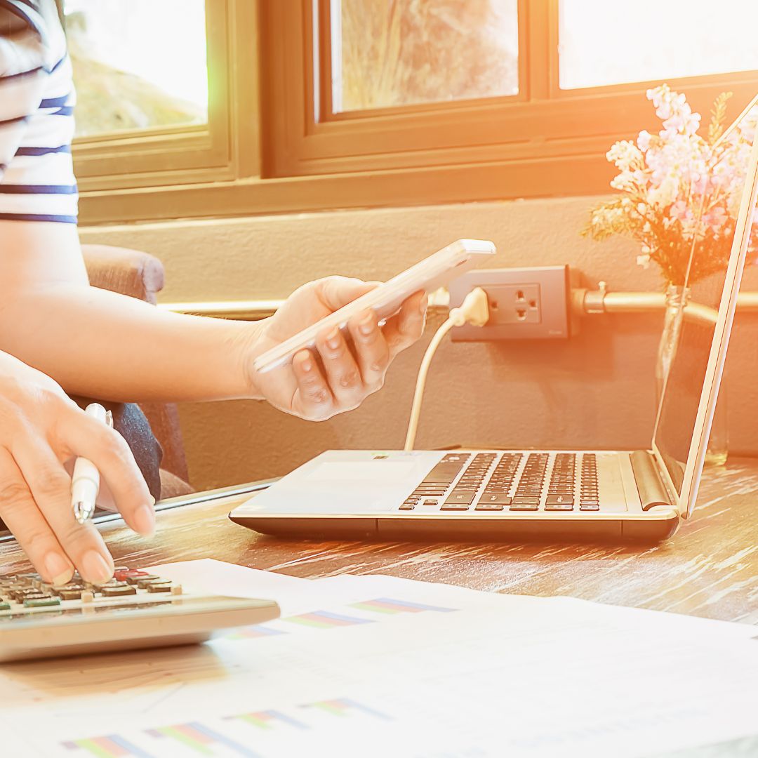 a person is sitting at a table with a laptop and a calculator